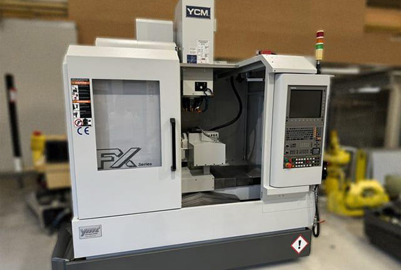 CNC machine model YCM FX series showcasing precision machining capabilities in a manufacturing environment compact design suitable for various machining tasks including 2 axis and 2 dimensional operations